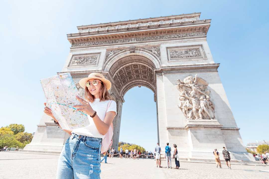 Tourist with Arch de Triomphe in the background in Paris, France