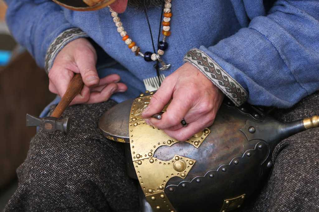 metal craftsman making a medieval soldiers helmet armor the old fashioned way