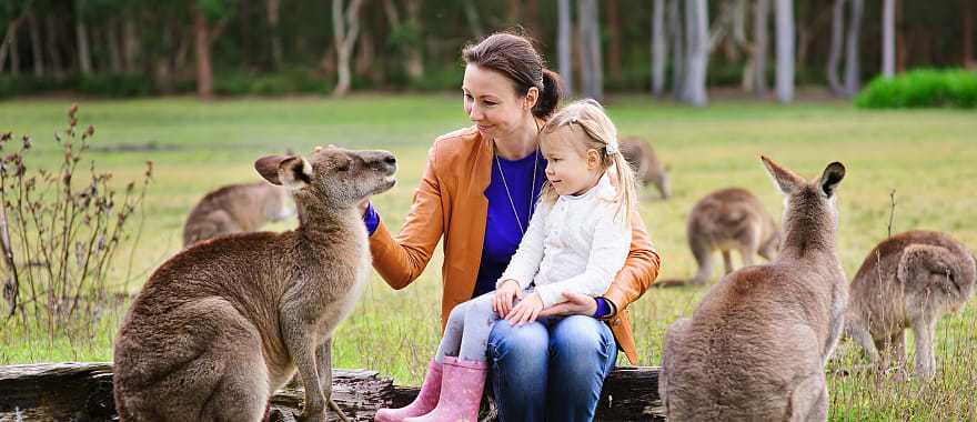 Mother and daughter feeding kangaroos in Australia