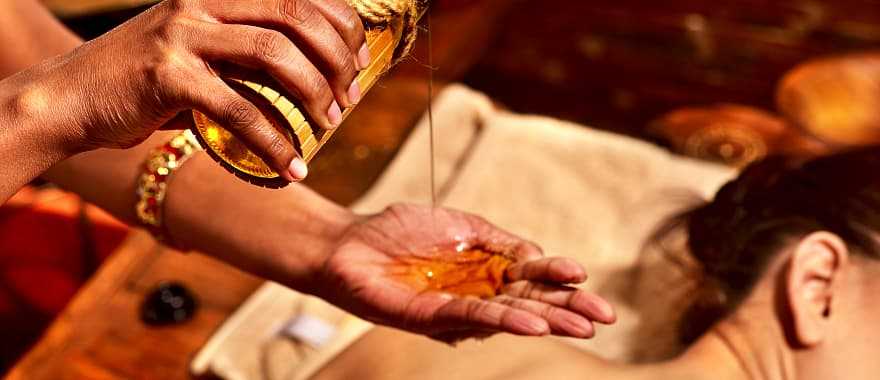 Women getting ayurvedic massage with oil in India.