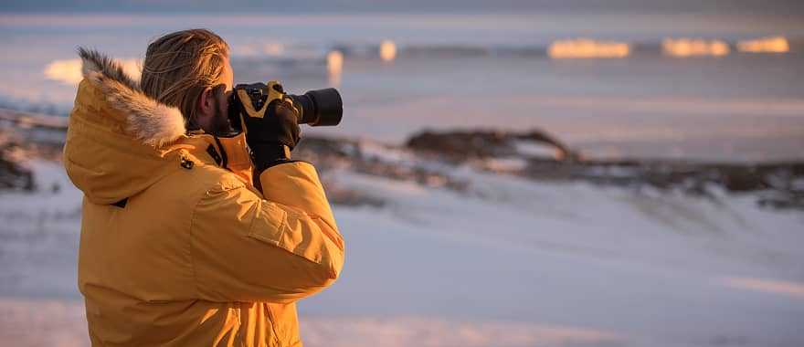 A traveler takes photos during an expedition to Antarctica