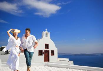 https://www.zicasso.com/sites/default/files/styles/image_style_tours_grid/public/photos/tour/greece-santorini-couple-enjoying-honeymoon-panorama-full.jpg
