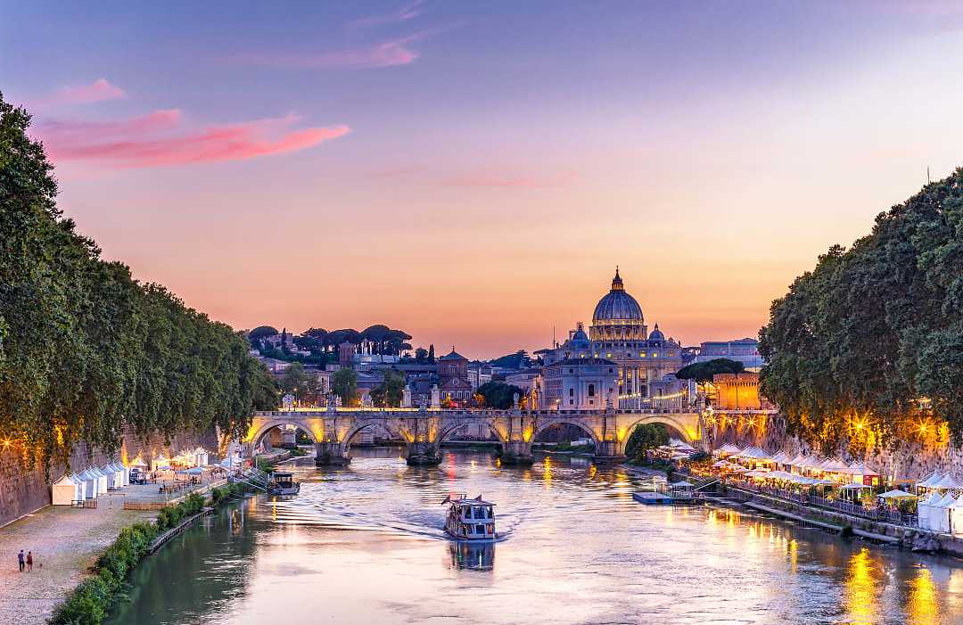 Dusk on a summer evening along the Tiber river with night market in Rome, Italy