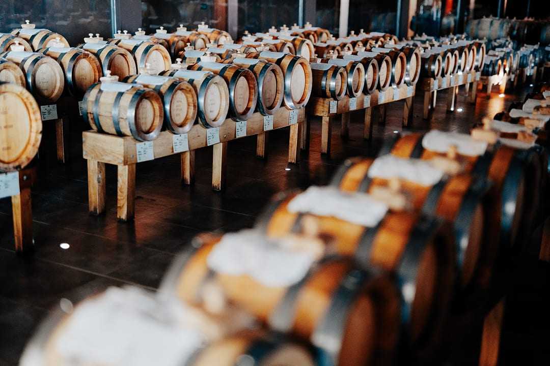Rows of small wooden barrels aging traditional balsamic vinegar in a Modena acetaia