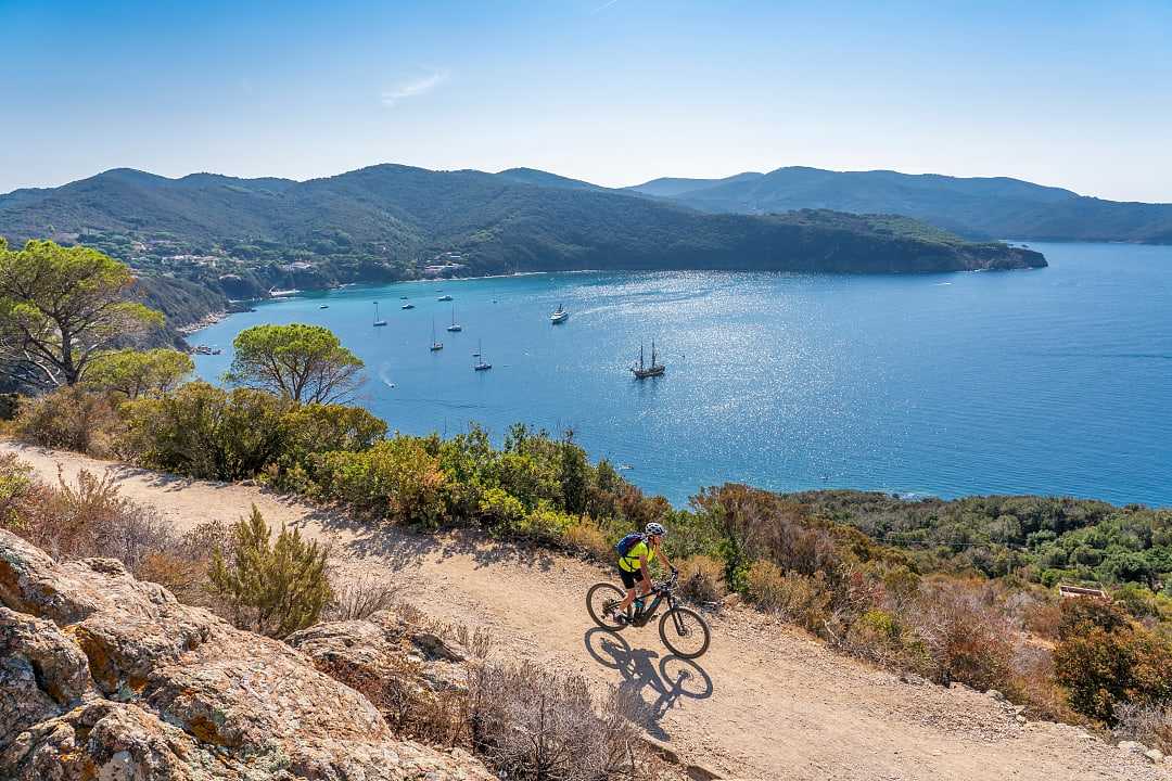 Biker with view of Elba Island in Tuscany, Italy