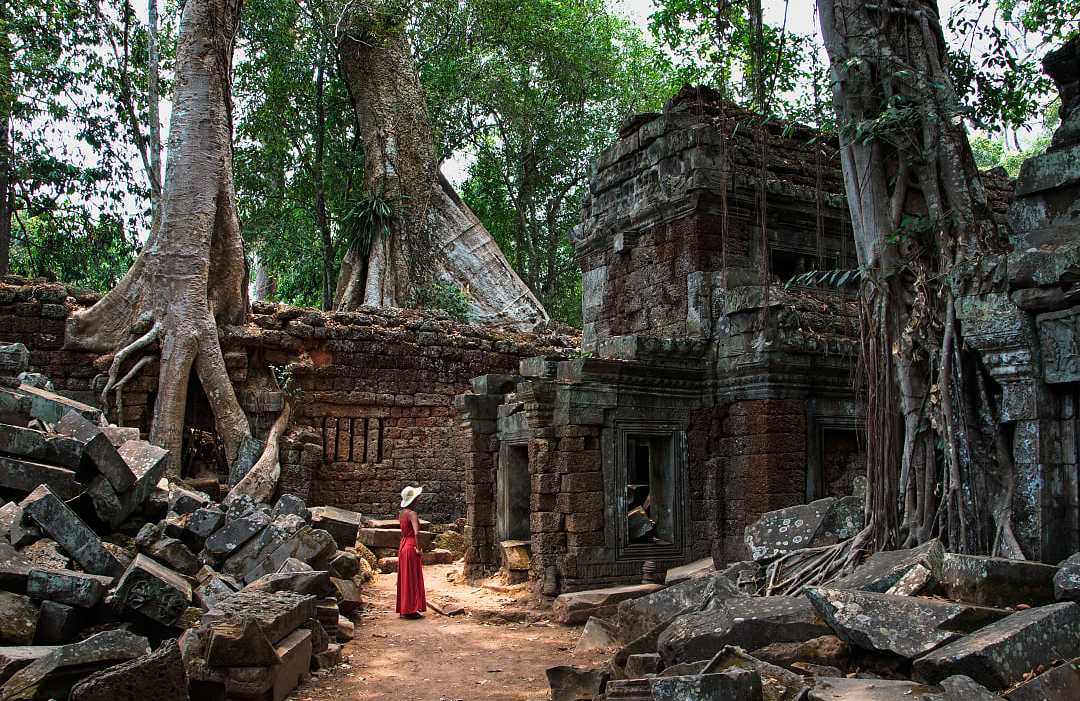 Ta Prohm Temple in Siem Reap, Cambodia Woman in a red dress at Ta Prohm Temple ruins in Siem Reap, Cambodia