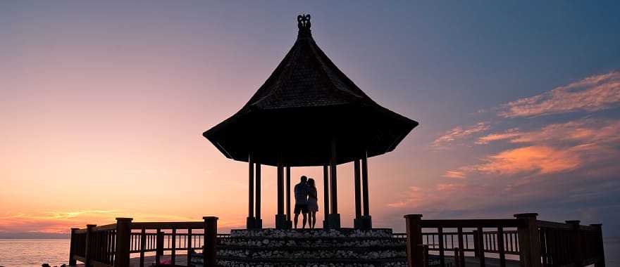Silhouette of couple enjoying romantic sunset in Bali
