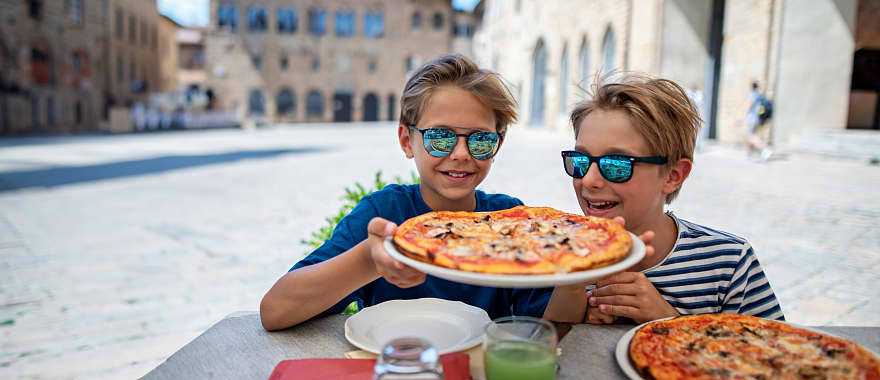 Boys enjoying a delicious Italian pizza. Boys enjoying a delicious Italian pizza.