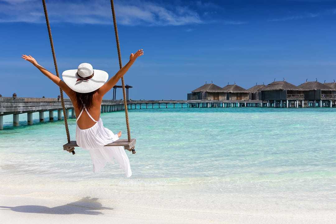 Woman enjoying a seaside swing in the Maldives