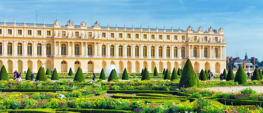 Lush green garden and Versailles building in France