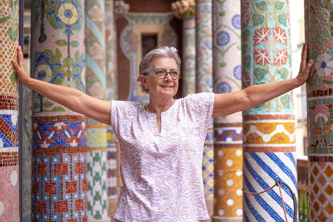 Senior traveler standing between colorful pillars at Palau de la Música Catalana in Barcelona, Spain