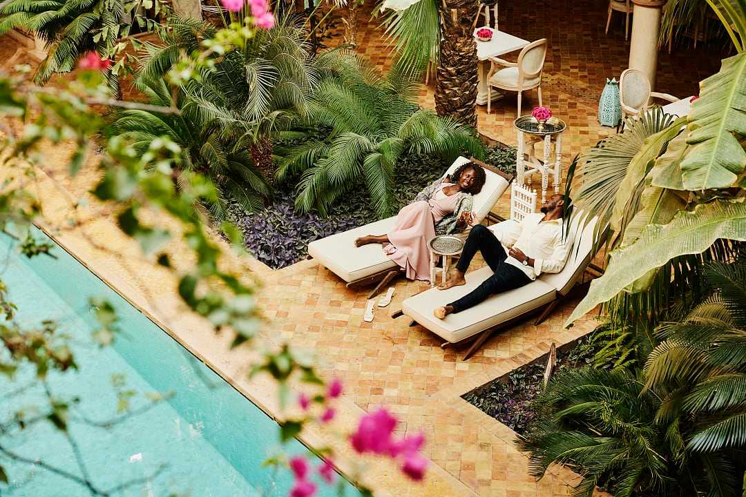 Couple at lounging by the pool at luxury riad in Marrakech, Morocco