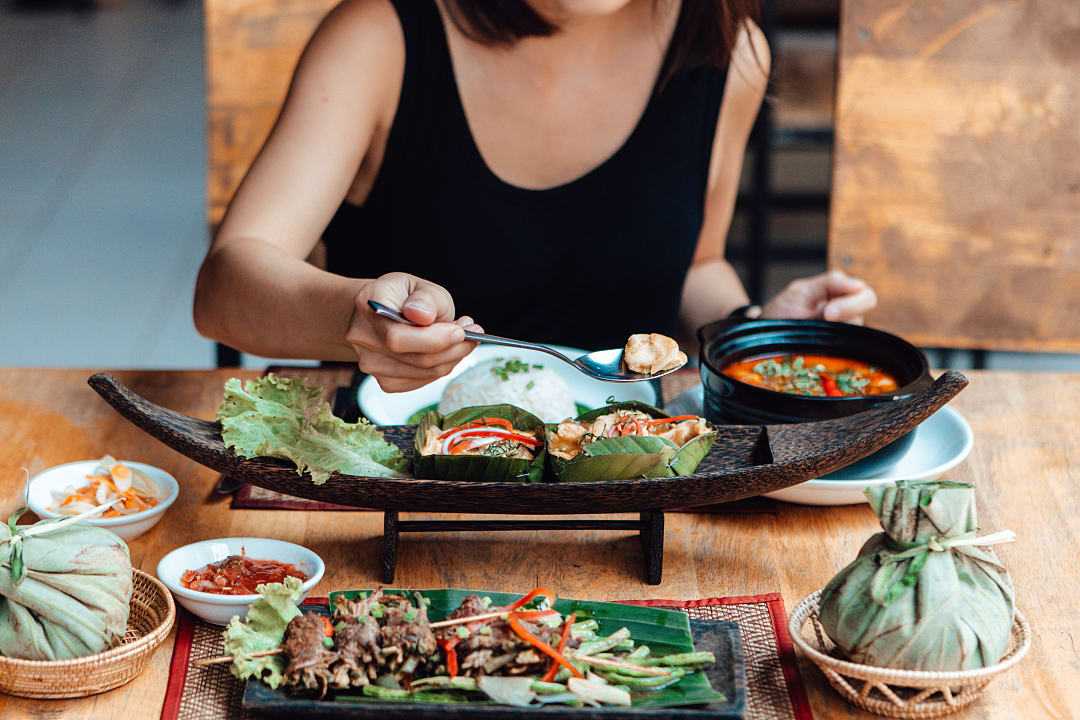 Woman enjoying mouthwatering Thai Cuisine