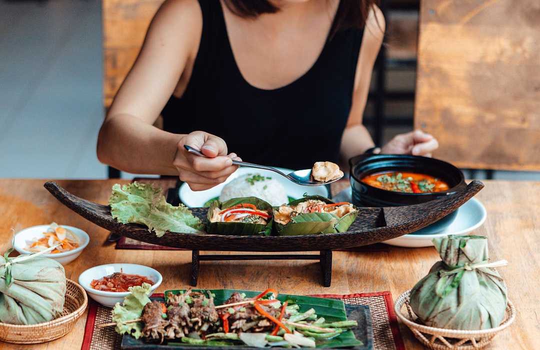 Bangkok, Thailand Woman enjoying mouthwatering Thai Cuisine