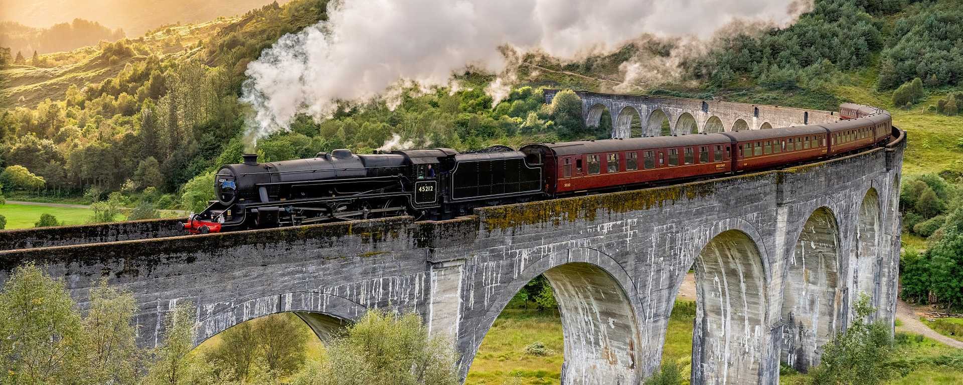 Steam train on the Glenfinnan Viaduct, made famous as the Hogwarts Express, in Scotland