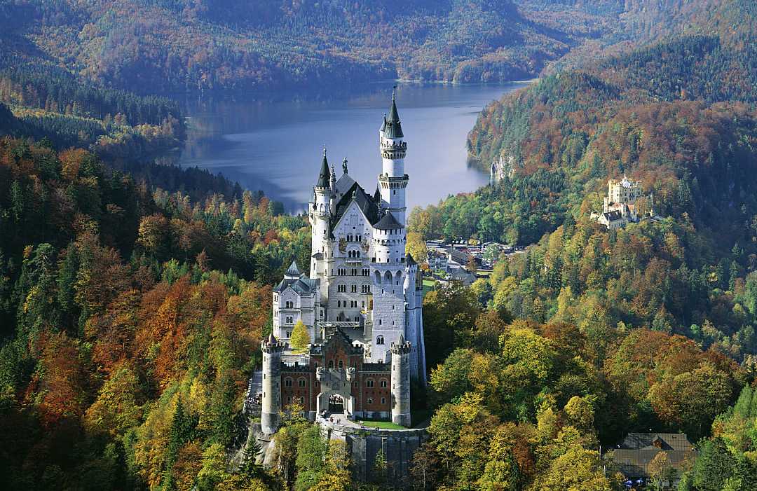 Neuschwanstein Castle in Bavaria, Germany Neuschwanstein Castle in Bavaria, Germany, surrounded by autumn forest and overlooking a mountain lake