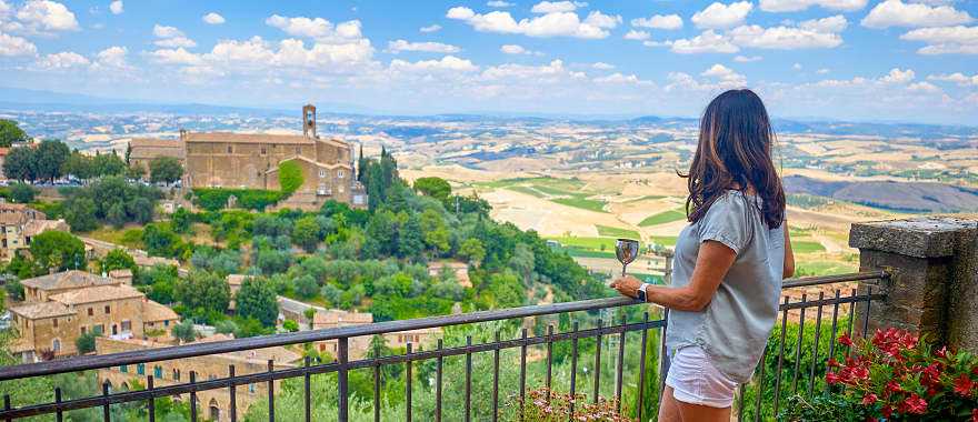 Woman enjoying a glass of wine and the view in Montalcino, Italy