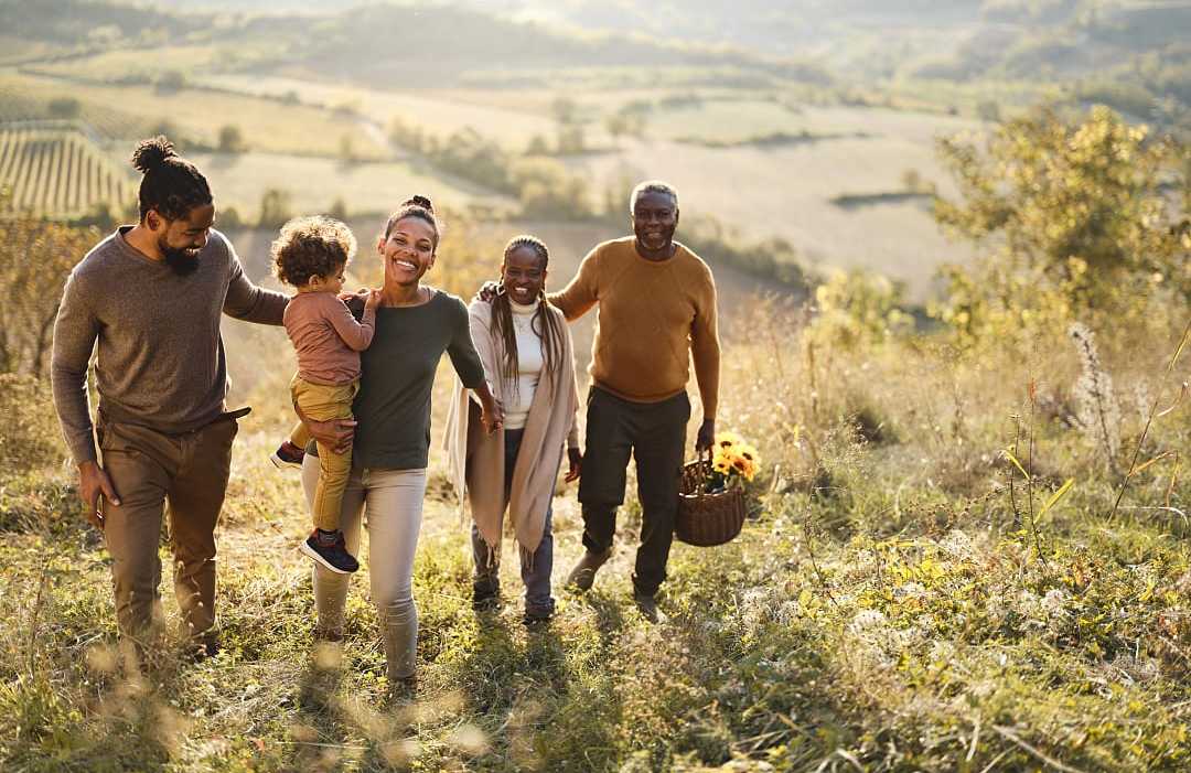 Multi-generational family exploring vineyards during the fall