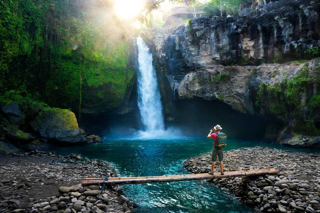 Hiker enjoying a waterfall in Bali, Indonesia 