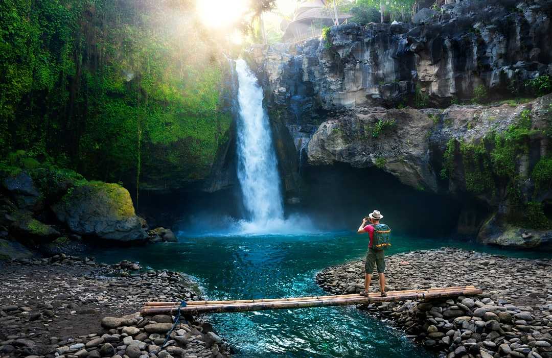 Bali, Indonesia Hiker enjoying a waterfall in Bali, Indonesia