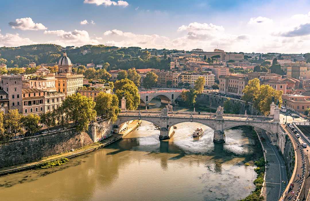 Ponte Vittorio Emanuele II, Rome in Italy. Elegant bridge spans Tiber River with Rome’s skyline behind.