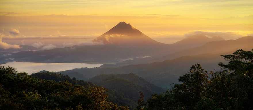 Arenal Volcano in Costa Rica Sunrise view of Arenal Volcano with clouds over Lake Arenal in Costa Rica