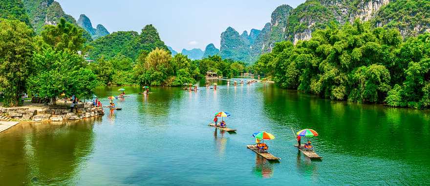 Tourists on bamboo boats floating down the Li River between the karsts in Guilin, China