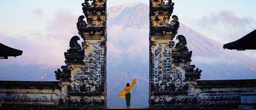 Solo female tourist at temple gates of Pura Penataran Agung Lempuyang, Bali, Indonesia.