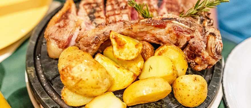 Traditional Florentine steak with baked potatoes and rosemary