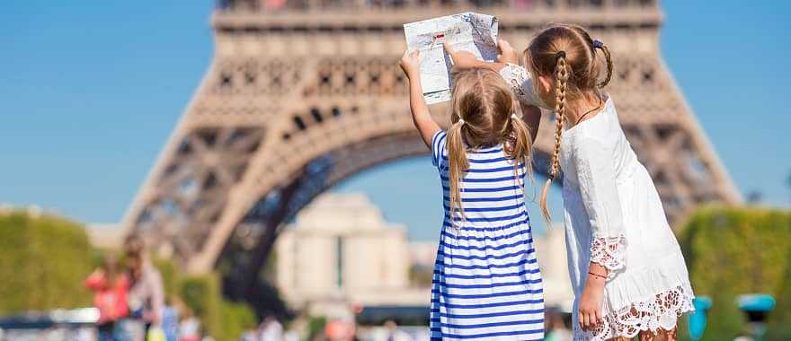 Little girls with a map of Paris on the background of the Eiffel tower, Paris
