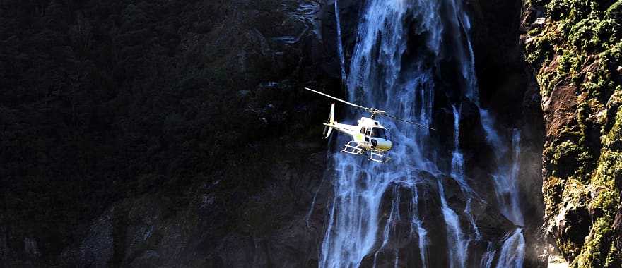 Helicopter flies over Fiordland National Park, New Zealand