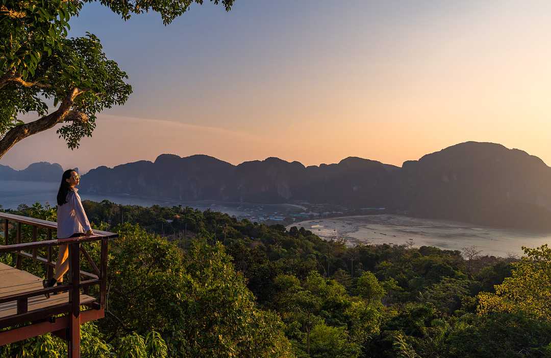 Phi Phi Islands, Thailand A woman standing at Phi Phi View Point watching the sunset