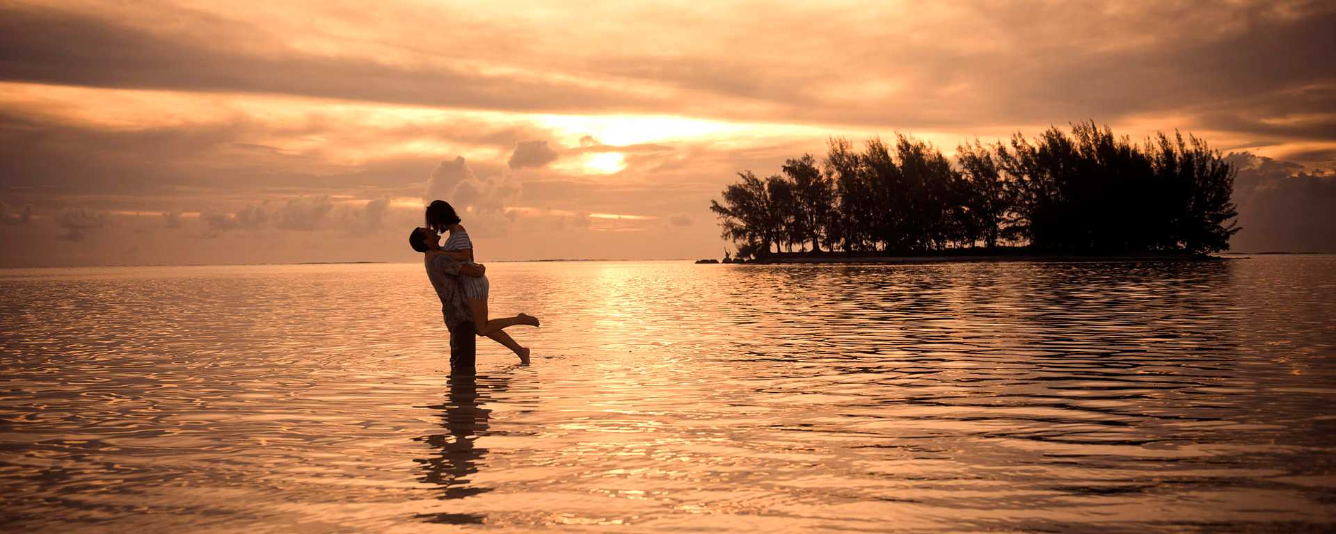 Honeymoon couple on the beach at sunset in Moorea, French Polynesia
