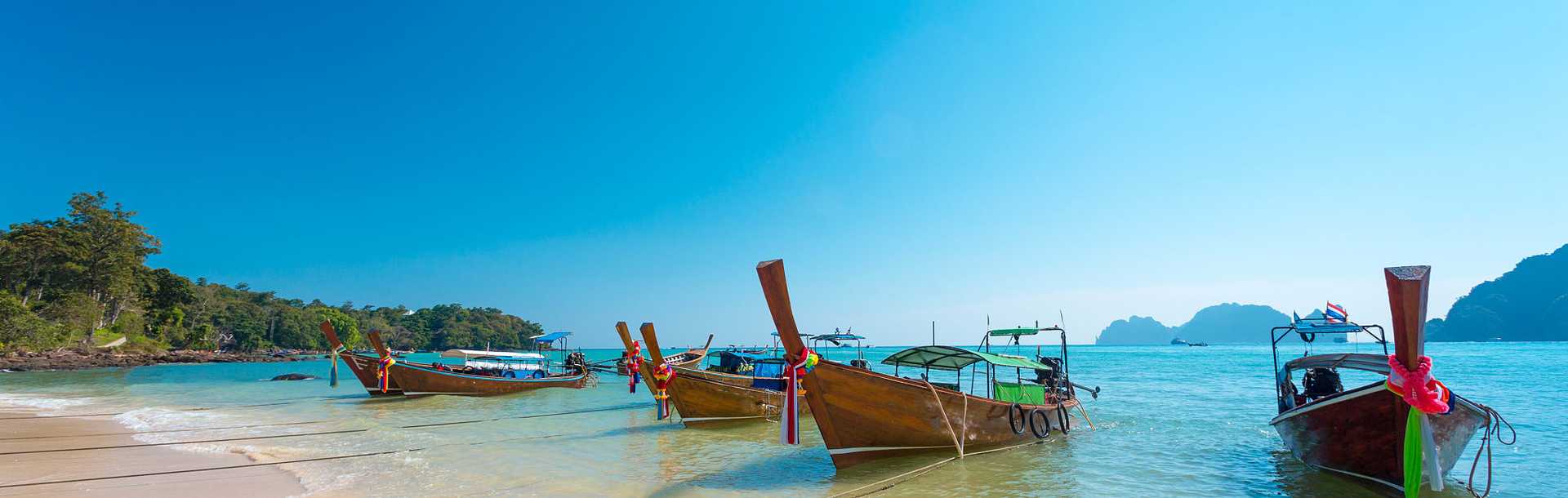 Boats on the beach with beautiful blue sky in Krabi, Thailand.