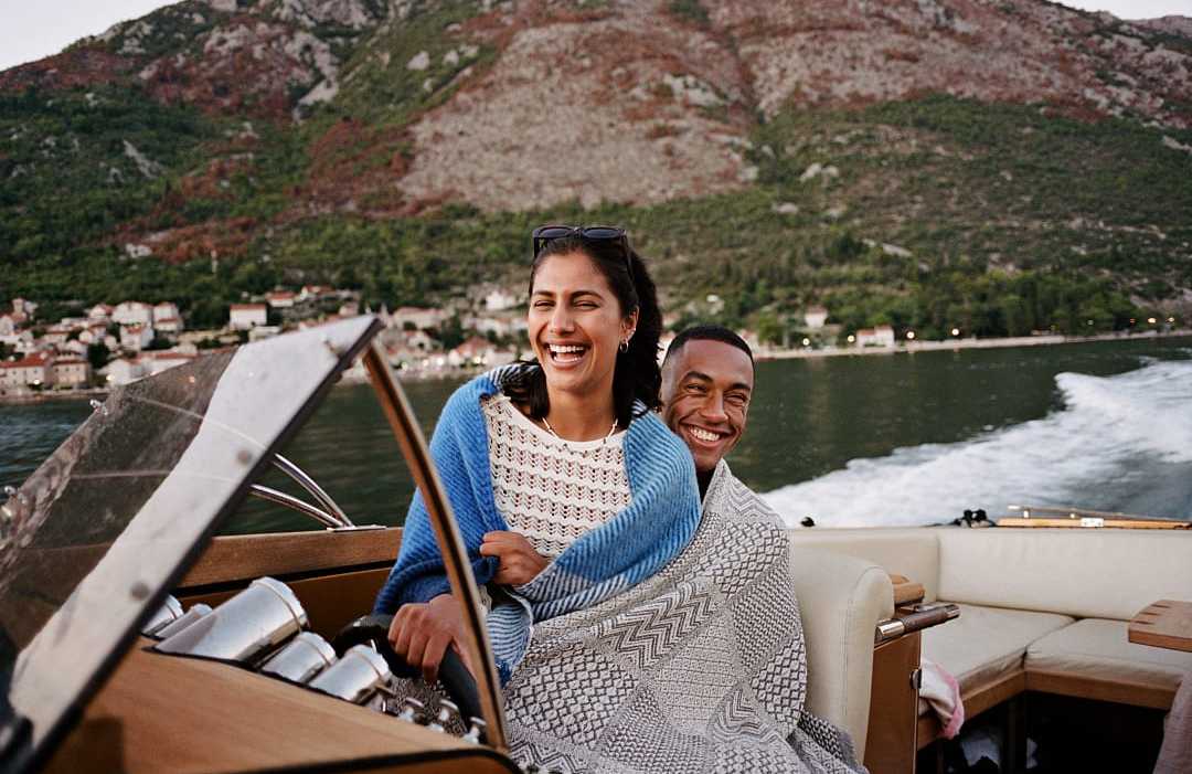 Couple enjoying a boat ride across the Bay of Kotor near Kotor, Montenegro
