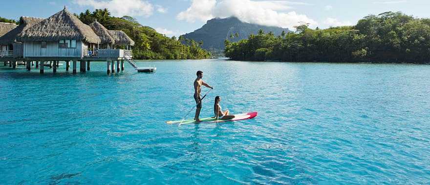 Couple stand up paddleboarding in Bora Bora, Tahiti 