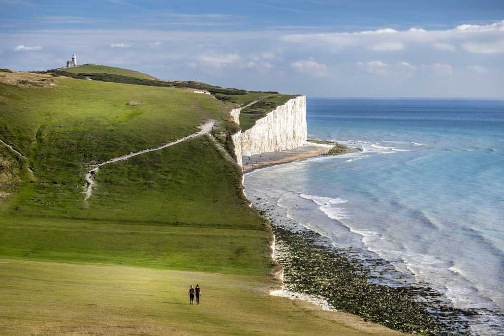 Couple walking on the Seven Sisters Chalk Cliffs on the South Coast of England
