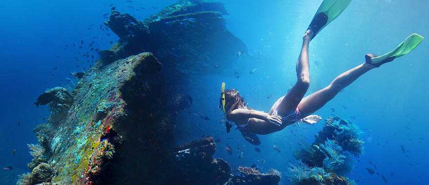 Woman exploring USAT Liberty wreckage off the coast of Bali