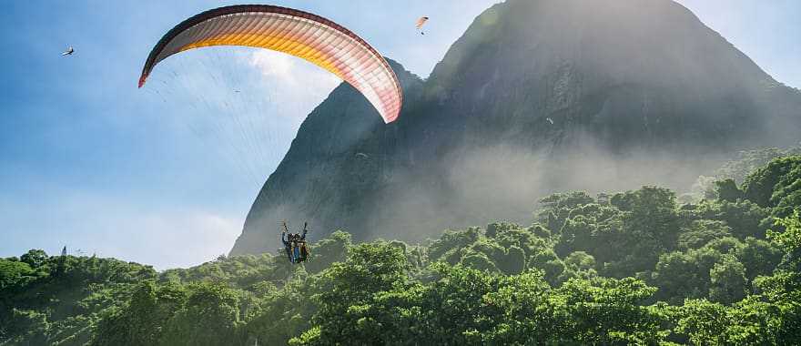 Couple on a romantic paragliding flight over the coast of Brazil