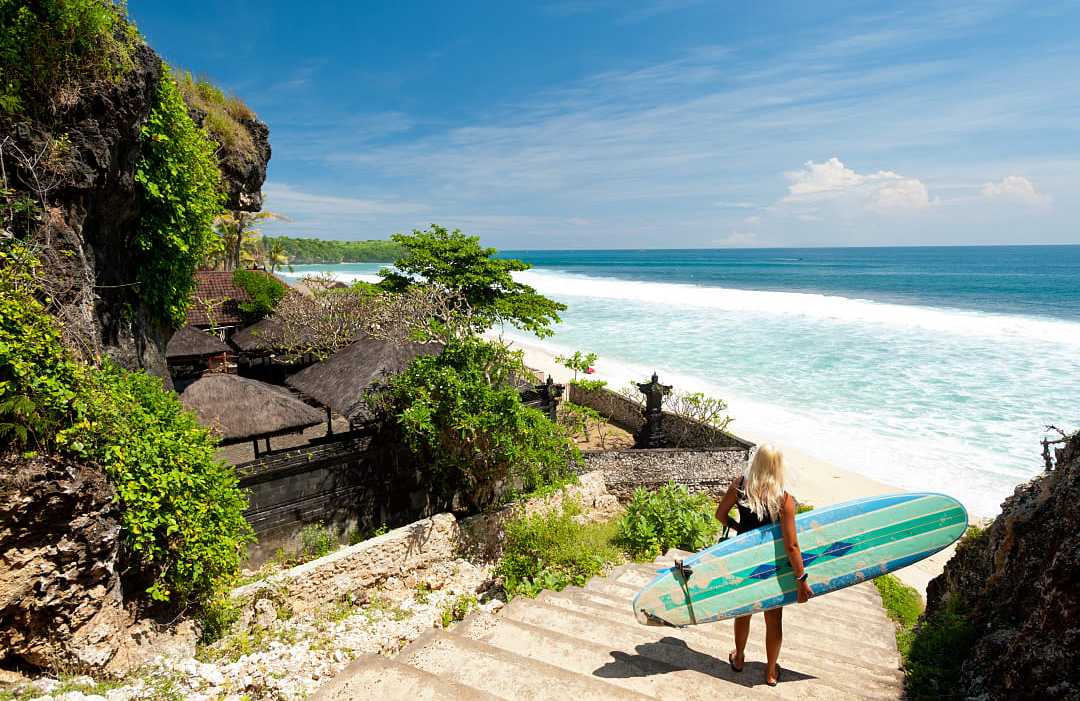 Surfer at tropical beach in Bali Surfer at a beach in Bali