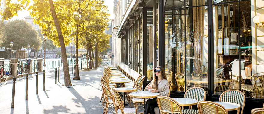 Woman sitting at an outdoor cafe in Paris, France