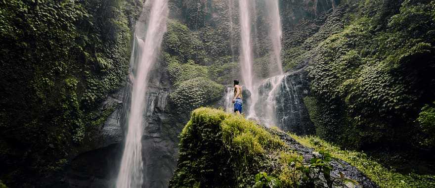 Traveler looking up at Sekempul Waterfall in Bali