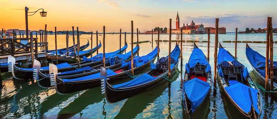 Row of traditional blue-colored gondolas parked on the Grand Canal, Venice, Italy