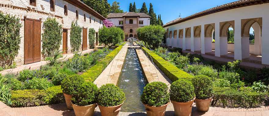 Garden and bell tower at Alhambra Palace in Granada in a beautiful summer day, Spain