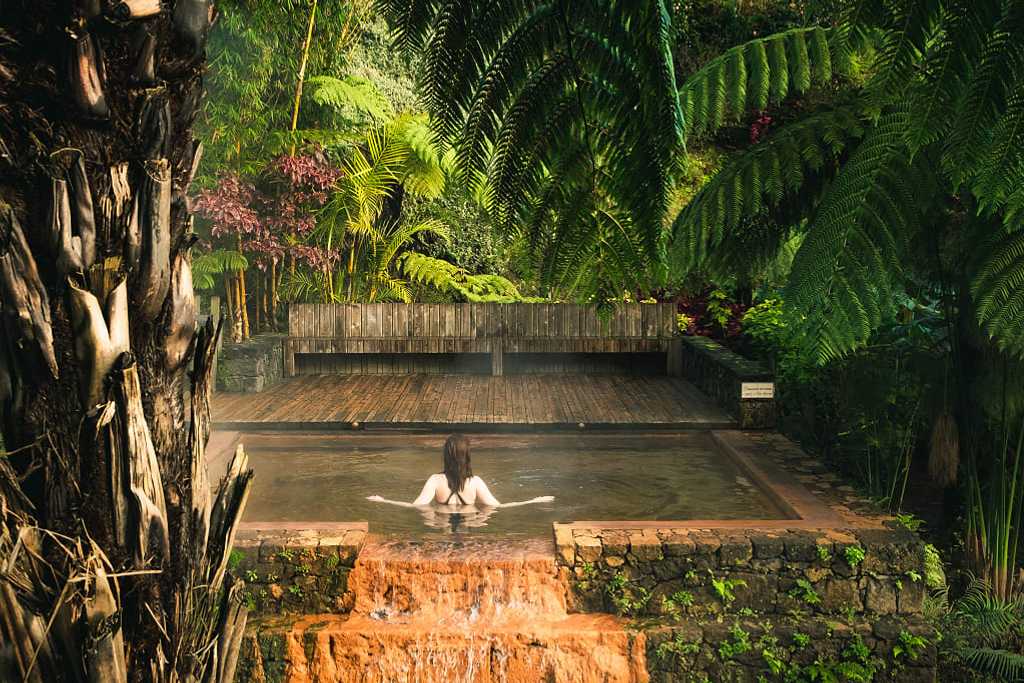 Female tourist enjoying hot springs pool at Poca da Dona Beija on Sāo Miguel, Azores
