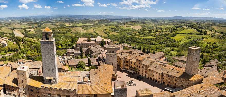 San Gimignano surrounded by the green rolling hills and vineyards of Tuscany, Italy