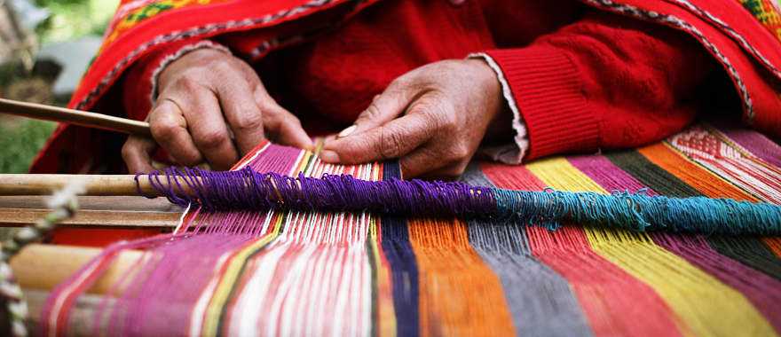 Woman weaving a traditional Peruvian blanket 