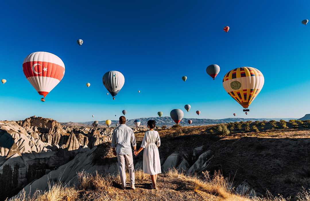 Cappadocia, Turkey Couple watching the hot air balloons launch in Cappadocia, Turkey