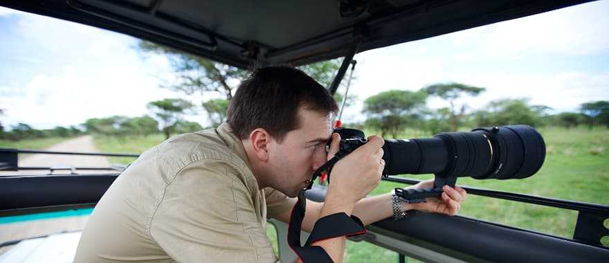 Photographer taking pictures on game drive in Tarangire National Park, Tanzania