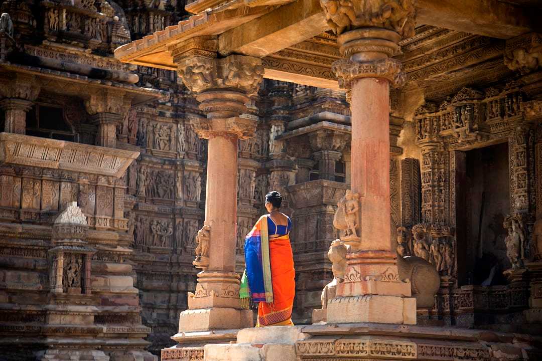 Indian women in colorful saree at Khajuraho Temple, UNESCO World Heritage Site, India.